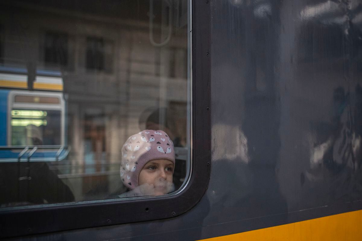 Un niño ucraniano mira por al ventilla del tren a su llegada a la estación de Praga.